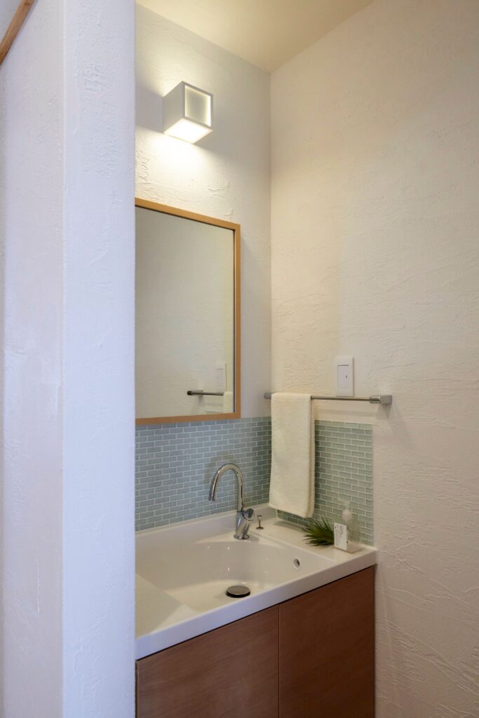 ２階洗面スペース　漆喰の壁にやさしい色合いのモザイクタイルがよく似合います
